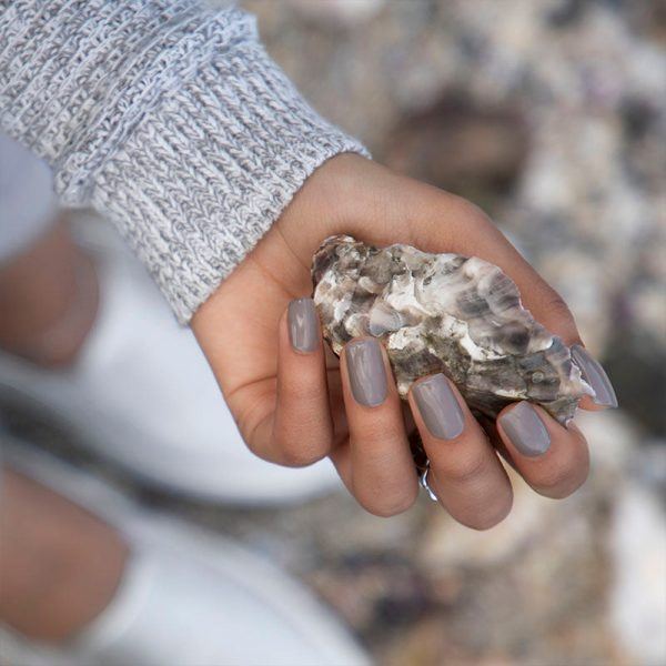 Image shows model wearing Bio Sculpture Gemini Nail Polish Oyster Shell No. 294, holding an oyster shell